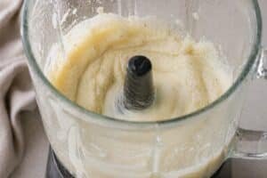 cauliflower being blended into a smooth creamy texture in a blender jar with visible motion and soft natural light