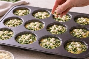 sprinkling crumbled feta over egg and spinach mixture in 12 cup muffin tin before baking